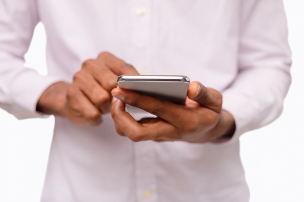 black-man-using-smartphone-browsing-social-media-o-QGFQMBL-min