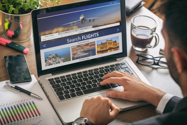 man-working-with-a-computer-search-flights-on-the--GQ8U32Z-min