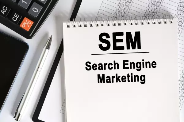 On the table lies a smartphone, a calculator and a notebook with the inscription- SEM.